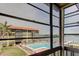 A screened lanai provides an expansive view of the community pool and ocean at 19701 Gulf Blvd # 328, Indian Shores, FL 33785