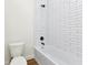 Clean bathroom featuring white tiled shower/tub and modern toilet at 2436 Jacobs St, Port Charlotte, FL 33953
