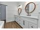 Well-lit bathroom with dual sinks, white cabinetry, and modern fixtures at 2436 Jacobs St, Port Charlotte, FL 33953