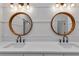 Bright bathroom featuring double vanity with quartz countertop and stylish round mirrors at 2436 Jacobs St, Port Charlotte, FL 33953