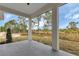 Covered patio shows view of the natural landscape, with mature pine trees, and grassy areas at 2436 Jacobs St, Port Charlotte, FL 33953