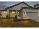Exterior of home at dusk boasts a modern elevation, attached garage, and fresh landscaping at 2436 Jacobs St, Port Charlotte, FL 33953