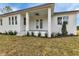 Quaint front porch has a ceiling fan, and manicured landscaping in the front of the lawn at 2436 Jacobs St, Port Charlotte, FL 33953