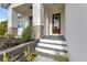 Inviting front porch with a modern glass door, stone accents, and new landscaping at 2436 Jacobs St, Port Charlotte, FL 33953