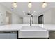 Large kitchen island featuring a farmhouse sink, stainless dishwasher, and modern fixtures at 2436 Jacobs St, Port Charlotte, FL 33953