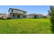 A large backyard features lush green grass and ample space, complemented by the home's light gray exterior at 36424 Sespe Creek Ct, Zephyrhills, FL 33540