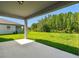 Covered back patio overlooking the home's backyard and wooded area at 36424 Sespe Creek Ct, Zephyrhills, FL 33540