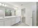 Bright primary bathroom with double sink vanity, framed mirror, and walk-in shower at 36424 Sespe Creek Ct, Zephyrhills, FL 33540