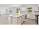 Modern kitchen featuring white cabinets, stainless steel appliances, and a center island at 36424 Sespe Creek Ct, Zephyrhills, FL 33540