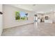 Spacious living room with large windows, tile flooring and access to modern kitchen at 36424 Sespe Creek Ct, Zephyrhills, FL 33540