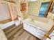 Cozy bathroom featuring a classic vanity, coordinated wallpaper, and a shower-tub combo at 6075 Shore S Blvd # 605, Gulfport, FL 33707