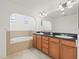 Bathroom featuring a soaking tub, vanity with dark counter and tile floors at 6211 S Macdill Ave # 1, Tampa, FL 33611