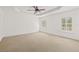 Spacious bedroom with a tray ceiling, fan, and shuttered windows at 6211 S Macdill Ave # 1, Tampa, FL 33611