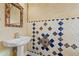 Stylish powder room with patterned blue tile backsplash, pedestal sink, and decorative mirror at 6211 S Macdill Ave # 1, Tampa, FL 33611