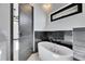 Bathroom featuring modern tub, black marble accents, and a high window at 6538 Simone Shores Cir, Apollo Beach, FL 33572