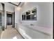 Bathroom boasts a double sink vanity with a large mirror, recessed lighting, and tiled floors at 6538 Simone Shores Cir, Apollo Beach, FL 33572