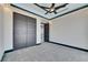 Well-lit bedroom featuring gray carpet, a ceiling fan, and a closet with modern doors at 6538 Simone Shores Cir, Apollo Beach, FL 33572