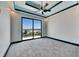 Modern bedroom featuring gray carpet, a ceiling fan, and a sliding glass door that leads to a balcony at 6538 Simone Shores Cir, Apollo Beach, FL 33572