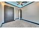 Modern bedroom features a ceiling fan, gray carpet, and an open closet with stylish dark doors at 6538 Simone Shores Cir, Apollo Beach, FL 33572