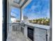 Modern outdoor kitchen features stainless steel appliances, stone countertops, and a beautiful view at 6538 Simone Shores Cir, Apollo Beach, FL 33572
