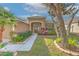 Inviting home entrance with double doors, mature landscaping, and a well-manicured lawn at 11147 Bridgecreek Dr, Riverview, FL 33569