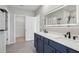 Elegant bathroom featuring a double vanity with marble countertops and stylish blue cabinetry at 2604 Knight Island Dr, Brandon, FL 33511