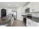 This modern kitchen features stainless steel appliances, granite countertops and bright white cabinets at 2604 Knight Island Dr, Brandon, FL 33511