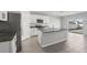 A modern kitchen with stainless steel appliances, a large island, granite countertops, and white cabinets at 2604 Knight Island Dr, Brandon, FL 33511