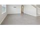 An empty living room has tile flooring, shiplap accent wall and a staircase at 2604 Knight Island Dr, Brandon, FL 33511