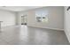 An empty living room with tile flooring, a sliding glass door, and a large window offers lots of natural light at 2604 Knight Island Dr, Brandon, FL 33511