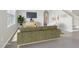 The staged living room has an olive green sofa and entertainment center with a large television screen at 2604 Knight Island Dr, Brandon, FL 33511