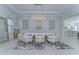 Sophisticated dining room featuring a large table with chic chairs, a decorative chandelier, and modern wall accents at 439 Bayview Ne Dr, St Petersburg, FL 33704