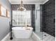 Luxurious bathroom featuring a soaking tub, glass-enclosed shower, and modern fixtures at 5292 Kernwood Ct, Palm Harbor, FL 34685