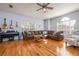 Spacious living room with a brown leather couch, hardwood floors, and natural light from the windows at 5292 Kernwood Ct, Palm Harbor, FL 34685