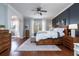 Spacious main bedroom with dark wood floors, ceiling fan and a light accent wall at 5292 Kernwood Ct, Palm Harbor, FL 34685