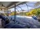 Outdoor pool area with comfortable seating, a screened enclosure, and lush landscaping at 5292 Kernwood Ct, Palm Harbor, FL 34685