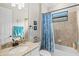 Bathroom with a blue shower curtain, granite countertop, and a coordinated set of towels and accessories at 5749 Cheech Gln, Bradenton, FL 34211