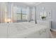 Bright bedroom with large windows, wood-style floors, and a white dresser, creating a serene atmosphere at 5749 Cheech Gln, Bradenton, FL 34211
