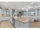 Open kitchen features a large island, white cabinetry, stainless steel appliances, and views of the living area at 5749 Cheech Gln, Bradenton, FL 34211