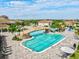 Aerial view of the large community pool with connecting rock bridge and plenty of lounge chairs at 5749 Cheech Gln, Bradenton, FL 34211