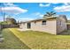 Back exterior of the home features sliding glass doors that lead to a concrete patio and fenced backyard at 6706 Sierra Ter, New Port Richey, FL 34652