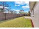Large backyard is surrounded by a wood fence, with plenty of green grass, and a concrete patio at 6706 Sierra Ter, New Port Richey, FL 34652