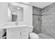 Bathroom featuring a vanity with a white countertop, a toilet, and a shower with decorative tile at 6706 Sierra Ter, New Port Richey, FL 34652