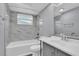 Updated bathroom features tub-shower combo with decorative tile surround, modern vanity, and toilet at 6706 Sierra Ter, New Port Richey, FL 34652