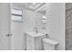 Modern bathroom with white vanity, toilet, and decorative light fixture above the mirror at 6706 Sierra Ter, New Port Richey, FL 34652