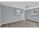 Bright bedroom features gray walls, wood-look floors, and two windows providing natural light at 6706 Sierra Ter, New Port Richey, FL 34652