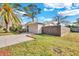 Charming single-story home with a well-manicured lawn, a fenced yard and driveway with mature trees at 6706 Sierra Ter, New Port Richey, FL 34652