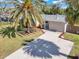 Exterior of house with a lush lawn, palm tree, long driveway, and manicured landscaping at 6706 Sierra Ter, New Port Richey, FL 34652