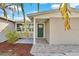 Inviting front entrance featuring a modern green door and stone walkway, surrounded by lush landscaping at 6706 Sierra Ter, New Port Richey, FL 34652