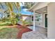 Inviting front entrance features a tiled porch, fresh landscaping, and a modern dark green front door at 6706 Sierra Ter, New Port Richey, FL 34652